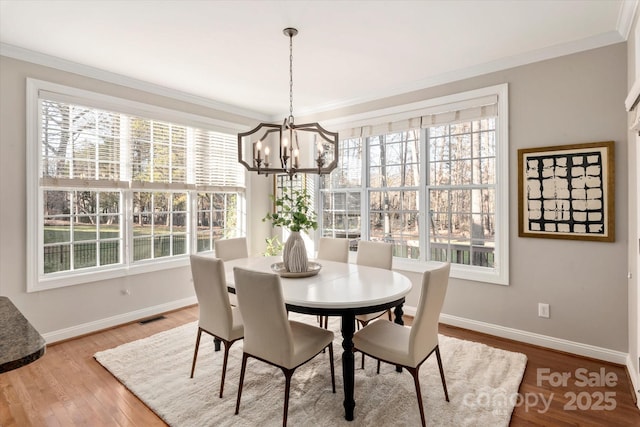 dining room featuring a chandelier, plenty of natural light, and crown molding