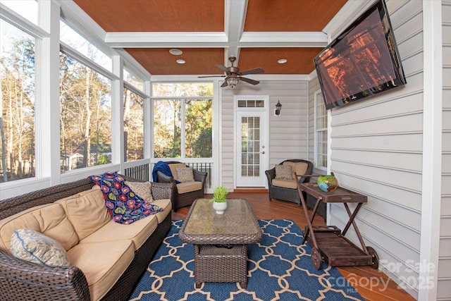 sunroom / solarium featuring coffered ceiling, wooden ceiling, ceiling fan, and beamed ceiling