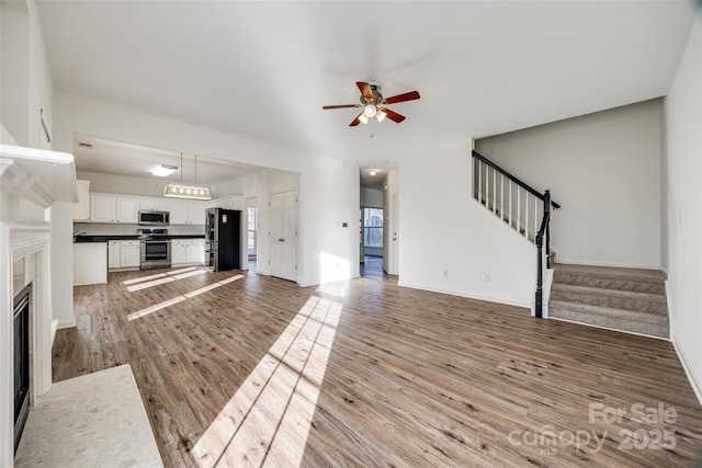 unfurnished living room featuring ceiling fan and wood-type flooring