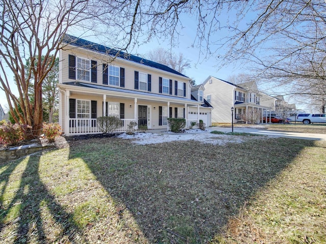 view of front of house featuring a garage, a front yard, and covered porch