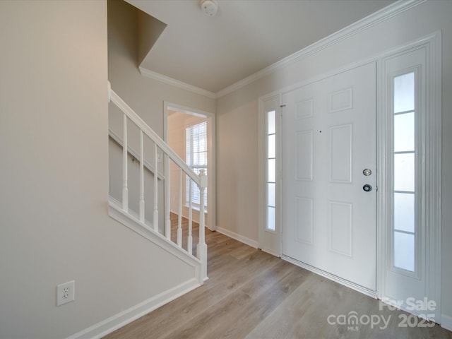 entryway with crown molding and light hardwood / wood-style floors