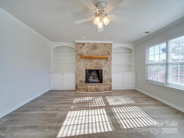 unfurnished living room featuring crown molding, light hardwood / wood-style floors, and built in features