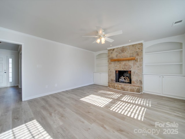 unfurnished living room with built in shelves, crown molding, light hardwood / wood-style flooring, ceiling fan, and a fireplace