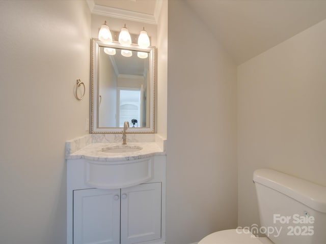 bathroom featuring vanity, ornamental molding, and toilet