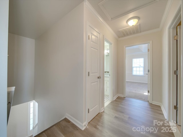 corridor featuring crown molding and light hardwood / wood-style flooring