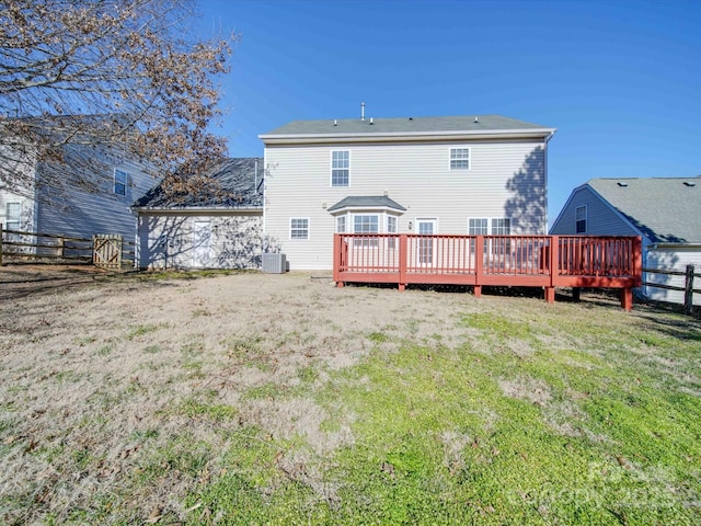 rear view of property featuring a wooden deck, a yard, and central air condition unit