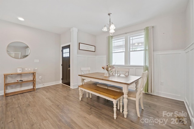 dining space featuring wood-type flooring and a chandelier