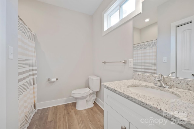 bathroom with hardwood / wood-style flooring, vanity, and toilet