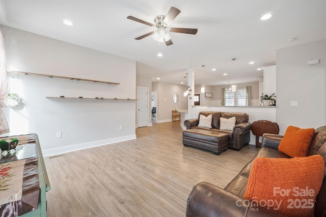 living room with light hardwood / wood-style flooring and ceiling fan