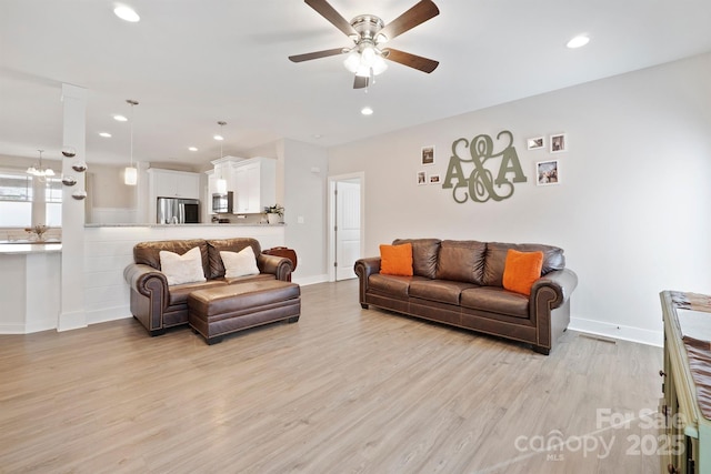 living room with light hardwood / wood-style floors and ceiling fan