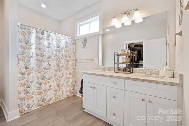 bathroom with vanity, curtained shower, and wood-type flooring