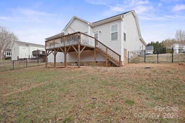 rear view of house with a wooden deck and a yard