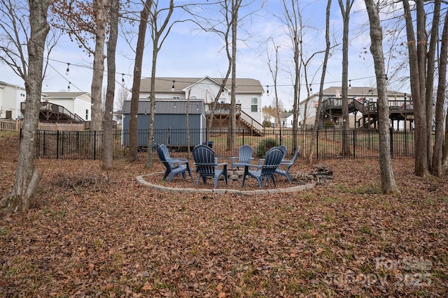 view of yard featuring a wooden deck and a fire pit