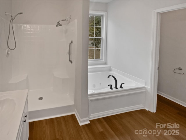 bathroom with shower with separate bathtub, vanity, and hardwood / wood-style flooring