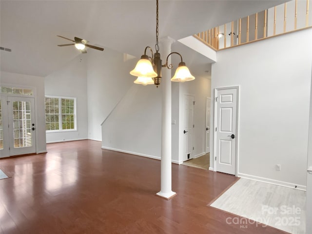 interior space featuring ceiling fan with notable chandelier, high vaulted ceiling, ornate columns, and dark hardwood / wood-style floors