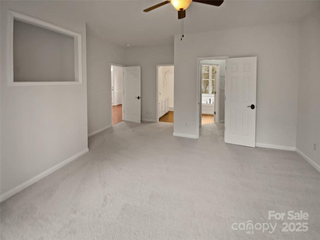 unfurnished bedroom featuring ensuite bath, ceiling fan, and light colored carpet