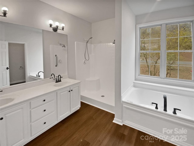 bathroom featuring hardwood / wood-style flooring, plus walk in shower, and vanity