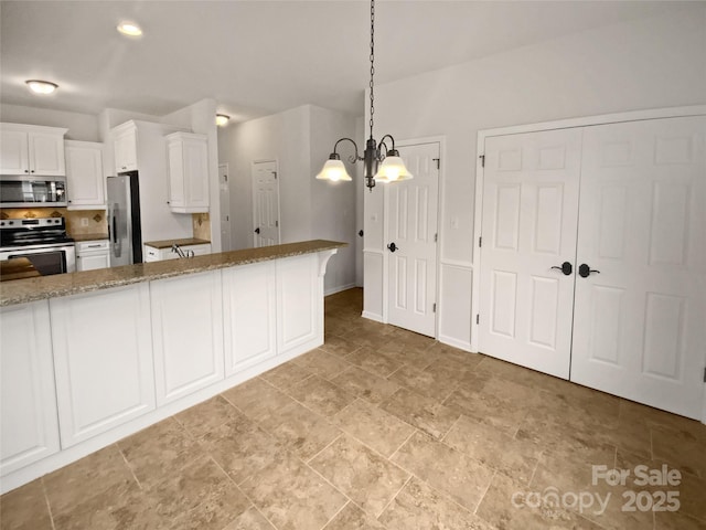 kitchen with stainless steel appliances, decorative light fixtures, white cabinetry, light stone counters, and a notable chandelier