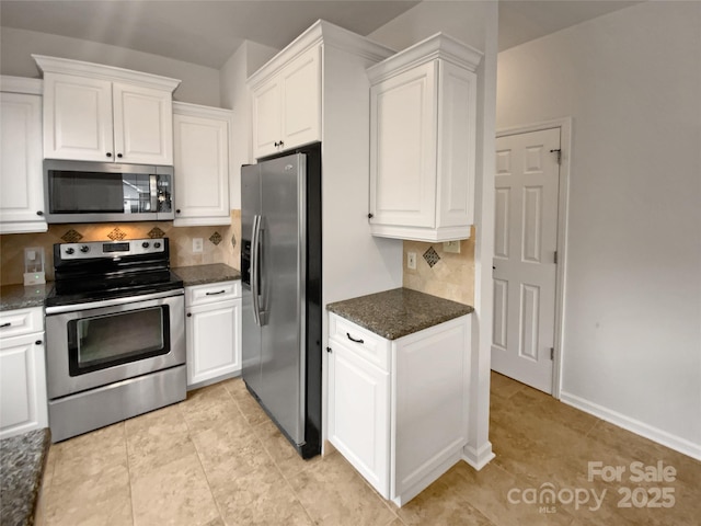 kitchen featuring stainless steel appliances, dark stone countertops, and white cabinets