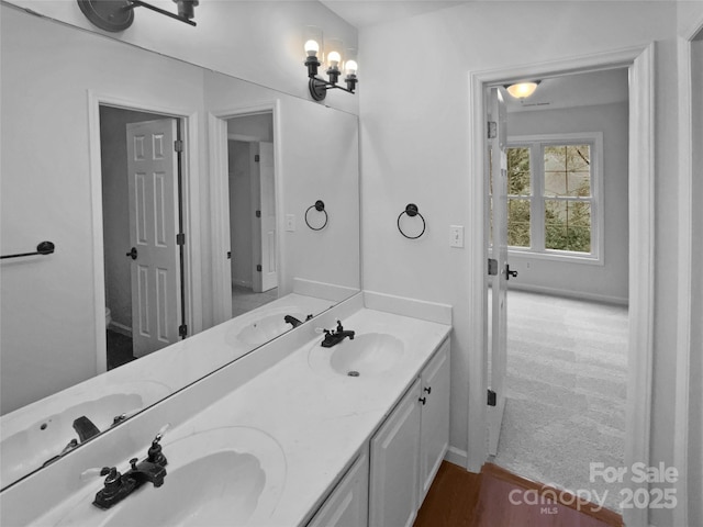 bathroom featuring hardwood / wood-style floors, an inviting chandelier, and vanity