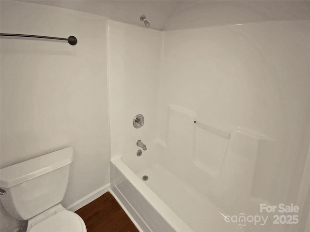 bathroom featuring toilet, wood-type flooring, and washtub / shower combination