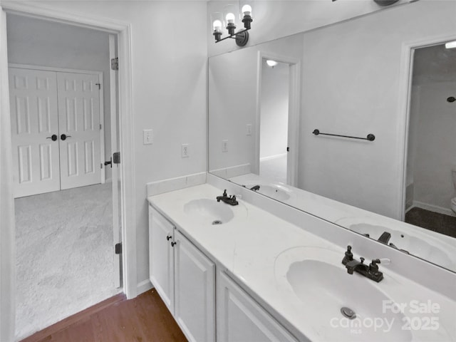 bathroom featuring hardwood / wood-style floors, an inviting chandelier, and vanity