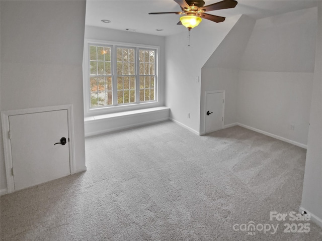 additional living space featuring light colored carpet, ceiling fan, and vaulted ceiling