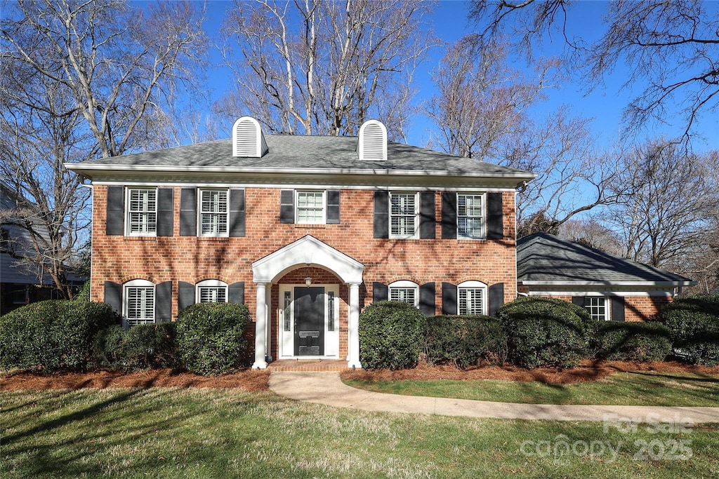 colonial inspired home with a front yard