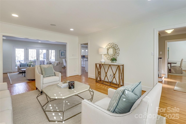 living room with hardwood / wood-style floors, ornamental molding, and french doors