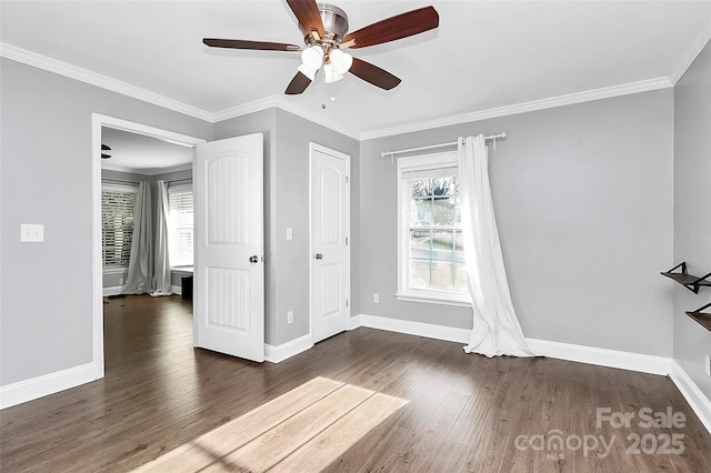 interior space with ceiling fan, a wealth of natural light, ornamental molding, and dark hardwood / wood-style floors