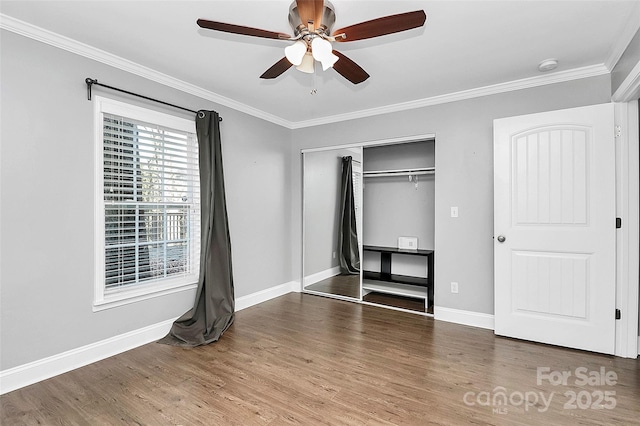 unfurnished bedroom with dark wood-type flooring, ceiling fan, ornamental molding, and a closet