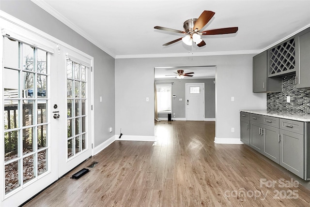 kitchen featuring tasteful backsplash, gray cabinetry, and ornamental molding