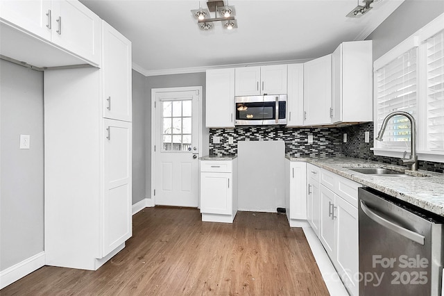 kitchen featuring light stone counters, sink, white cabinetry, and appliances with stainless steel finishes