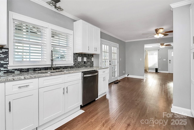 kitchen featuring white cabinetry, decorative backsplash, dishwasher, light stone counters, and sink