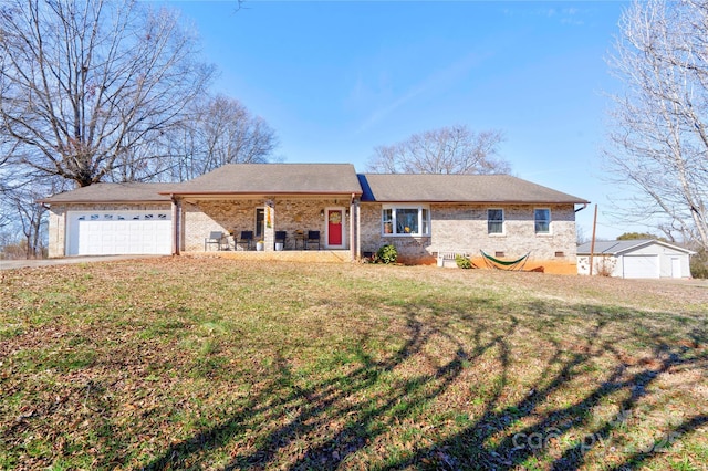 single story home with a front yard, covered porch, brick siding, and an attached garage