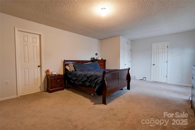 carpeted bedroom with a textured ceiling and baseboards