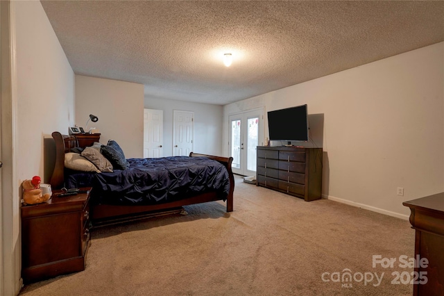 bedroom featuring a textured ceiling, french doors, carpet flooring, and baseboards