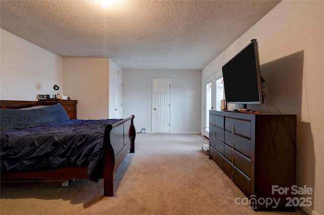 bedroom featuring light carpet and a textured ceiling