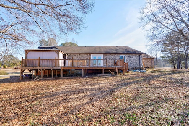 rear view of house with brick siding and a wooden deck