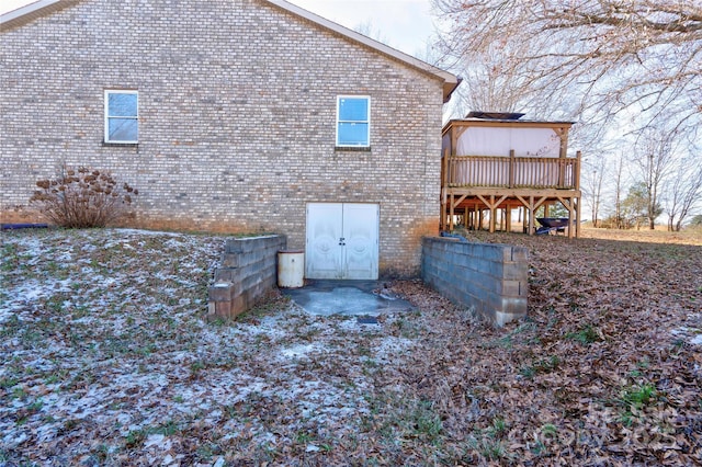 back of property featuring brick siding and a wooden deck