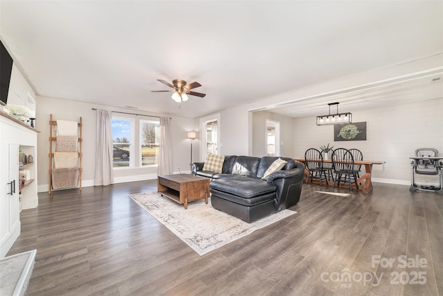 living room featuring ceiling fan and dark wood-type flooring