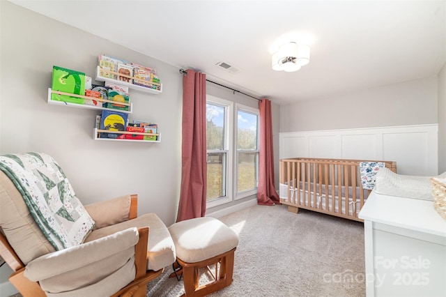 bedroom featuring light carpet and a crib