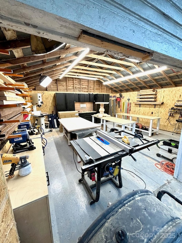 rec room featuring lofted ceiling and a workshop area