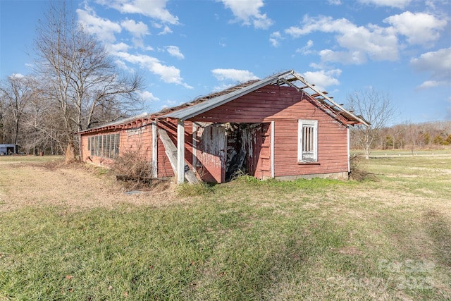 view of side of property with a yard and an outdoor structure