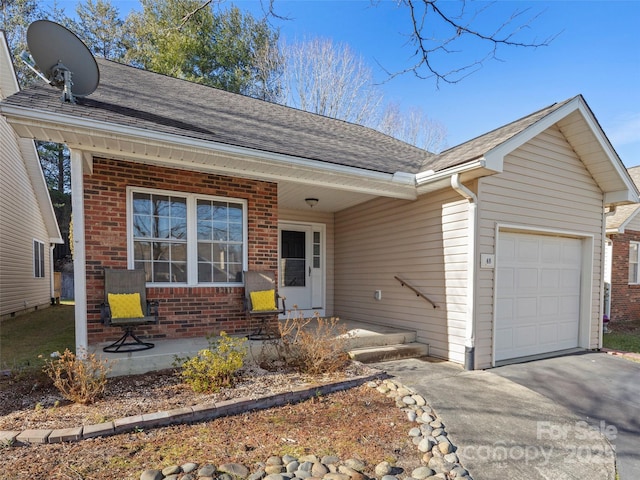 single story home featuring a porch and a garage