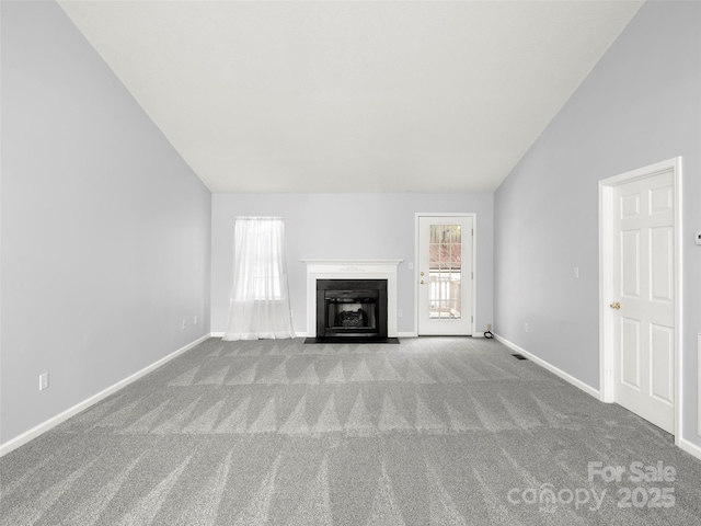 unfurnished living room with light colored carpet and vaulted ceiling