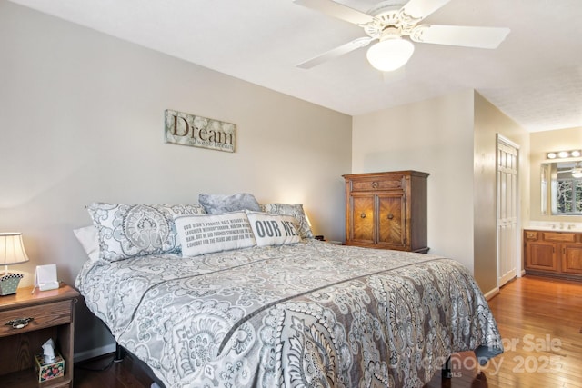 bedroom featuring ceiling fan, ensuite bathroom, and hardwood / wood-style flooring