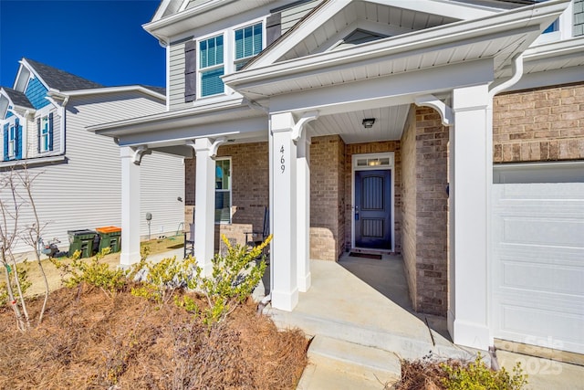 entrance to property featuring a porch and a garage