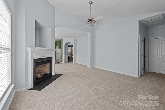 unfurnished living room with light carpet, ceiling fan, and vaulted ceiling