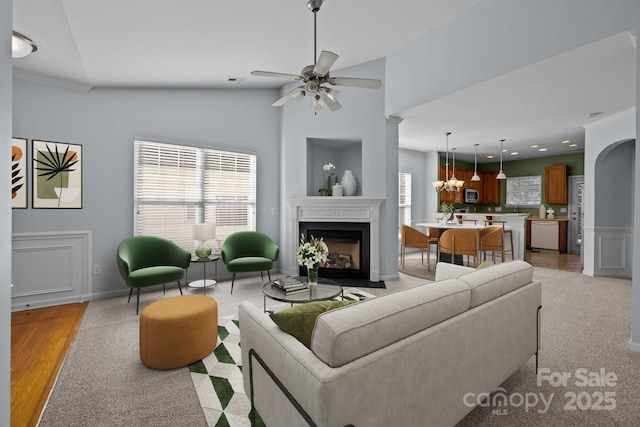 living room with vaulted ceiling and ceiling fan with notable chandelier